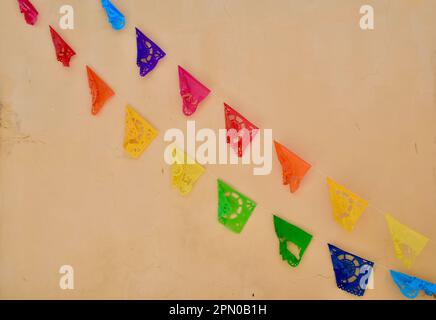 Papel coloré picado (papier perforé) contre un mur dans la ville jaune d'Izamal, Yucatan, Mexique. Banque D'Images