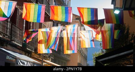 Les drapeaux LGBTQ+ brillent au coucher du soleil sur Chueca Streets. Bannière Banque D'Images