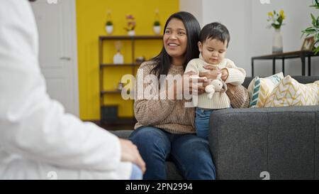 Couple et fils souriant confiant ayant une consultation médicale à la clinique Banque D'Images