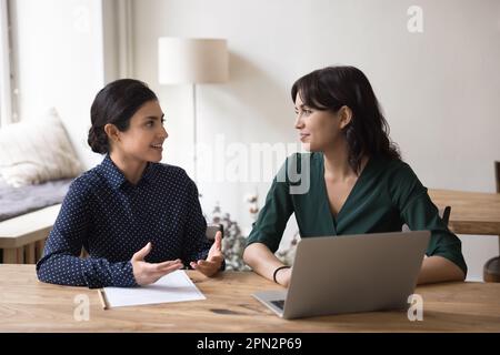 Deux femmes collègues travaillent ensemble, coopèrent, engagées dans le travail d'équipe Banque D'Images
