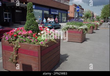 Paniers de fleurs suspendus et présentoirs en boîte de magasins et d'autres entreprises près de la barre de Stratford animée à Shirley, Solihull, West Midlands en août 2010. Série 5849-5851-Stratford Road Shirley Solihull/Beatties Solihull Banque D'Images