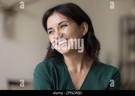 Portrait de la belle jeune femme heureuse regardant de côté poser à l'intérieur Banque D'Images