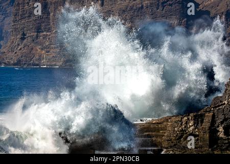 Le puissant océan envoie une énorme vague s'écrasant contre le rivage rocheux, créant une exposition spectaculaire de puissance naturelle à Acantilados de los Gigantes Banque D'Images