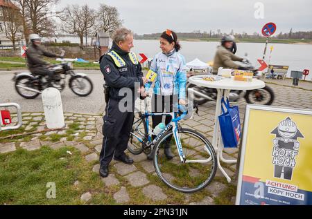 Hambourg, Allemagne. 16th avril 2023. Michael Jensen, officier de police, et Sonja Eilers, cycliste, se tiennent à un stand d'information de la police sur la digue au quai du ferry de Zollenspieker à Hambourg-Kirchwerder. Dimanche, la police de Hambourg et ses organisations partenaires tiennent une journée d'information de la police pour lancer la saison des motocyclistes et des cyclistes. Credit: Georg Wendt/dpa/Alay Live News Banque D'Images