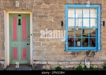 Porte d'entrée rose pastel et verte et fenêtre à guillotine dans un cottage géorgien traditionnel à Bridport, Dorset. Concept traditionnel cottage devant. Banque D'Images