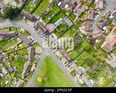 Vue aérienne en haut vers le bas de la plupart des maisons semi-individuelles vues dans un village typiquement anglais. La zone centrale affiche un espace vert commun. Banque D'Images