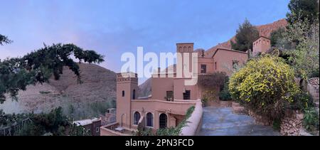 Maroc : coucher de soleil rose, vue de conte de fées sur les montagnes du Haut Atlas depuis les jardins en terrasses de l'Auberge chez Pierre, hôtel juste en dessous des gorges du Dadès Banque D'Images