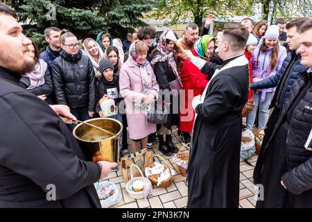 Un prêtre bénit la nourriture de Pâques avec l'eau sainte comme les croyants ukrainiens participent à la célébration traditionnelle du dimanche de Pâques à Saint Monastère à la Domée d'or de Michael, dans le centre de Kiev, la capitale de l'Ukraine sur 16 avril 2023. Selon la tradition, les fidèles apportent leur nourriture de Pâques dans un panier à purifier, il est toujours Pasha (pain de Pâques), oeuf peint (pysanka) entre autres. La plupart des Ukrainiens sont des chrétiens orthodoxes ou des chrétiens catholiques grecs, tous deux observent le rite oriental de Pâques. Kiev reste relativement pacifique alors que l'invasion russe se poursuit et que l'Ukraine se prépare pour un pays de printemps Banque D'Images