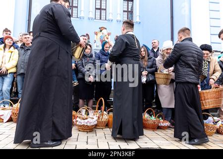 Un prêtre bénit la nourriture de Pâques avec l'eau sainte comme les croyants ukrainiens participent à la célébration traditionnelle du dimanche de Pâques à Saint Monastère à la Domée d'or de Michael, dans le centre de Kiev, la capitale de l'Ukraine sur 16 avril 2023. Selon la tradition, les fidèles apportent leur nourriture de Pâques dans un panier à purifier, il est toujours Pasha (pain de Pâques), oeuf peint (pysanka) entre autres. La plupart des Ukrainiens sont des chrétiens orthodoxes ou des chrétiens catholiques grecs, tous deux observent le rite oriental de Pâques. Kiev reste relativement pacifique alors que l'invasion russe se poursuit et que l'Ukraine se prépare pour un pays de printemps Banque D'Images