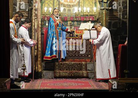 Le prêtre Behnam Konutgan dirige la messe à l'église de la Vierge Marie à Diyarbakir avec son assistant de clergyman et deux jeunes Assyriens. Les derniers Assyriens de Diyarbakir, composés de deux familles et d'un total de 12 personnes, ont célébré la fête de Pâques avec une messe tenue à l'église de la Vierge Marie. Le prêtre Behnam Konutgan, qui a été commandé du monastère de Mardin Deyrul Zaferan parce qu'il n'y avait pas de religieux dans la ville qui pouvait administrer le rite, l'a dirigé. Un petit nombre d'Assyriens et de leurs amis arméniens ont également assisté à la messe. Après la masse, des petits pains spécialement cuits et des œufs rouges étaient Banque D'Images