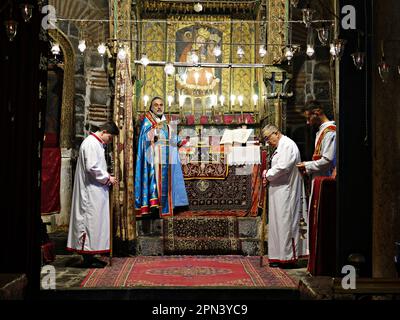 Le prêtre Behnam Konutgan dirige la messe à l'église de la Vierge Marie à Diyarbakir avec son assistant de clergyman et deux jeunes Assyriens. Les derniers Assyriens de Diyarbakir, composés de deux familles et d'un total de 12 personnes, ont célébré la fête de Pâques avec une messe tenue à l'église de la Vierge Marie. Le prêtre Behnam Konutgan, qui a été commandé du monastère de Mardin Deyrul Zaferan parce qu'il n'y avait pas de religieux dans la ville qui pouvait administrer le rite, l'a dirigé. Un petit nombre d'Assyriens et de leurs amis arméniens ont également assisté à la messe. Après la masse, des petits pains spécialement cuits et des œufs rouges étaient Banque D'Images