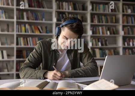 Exercice d'écoute d'un élève à l'aide d'un casque préparer l'exercice à la bibliothèque Banque D'Images