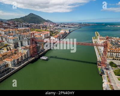 Une vue aérienne d'un immense pont suspendu rouge au-dessus de l'eau à Bilbao, en Espagne Banque D'Images