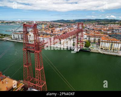 Une vue aérienne d'un immense pont suspendu rouge au-dessus de l'eau à Bilbao, en Espagne Banque D'Images