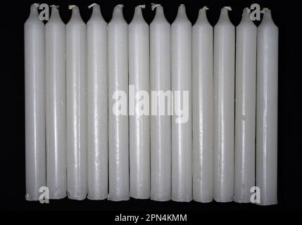 Bougies de paraffine blanches sur fond noir. Bougies maison dans un tas. Banque D'Images