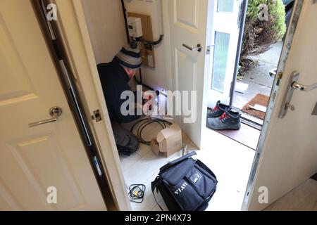 Un homme de BT Openreach photographié installant la fibre optique large bande dans une maison à Chichester, West Sussex, Royaume-Uni. Banque D'Images