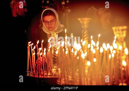 Les croyants ukrainiens allument des bougies pendant les célébrations du Saint dimanche à Saint-Laurent Monastère Golden-Domed de Michael dans le centre de Kiev. Selon la tradition, les fidèles apportent leur nourriture de Pâques dans un panier à purifier, il est toujours Pasha (pain de Pâques), oeuf peint (pysanka) entre autres. La plupart des Ukrainiens sont des chrétiens orthodoxes ou des chrétiens catholiques grecs, tous deux observent le rite oriental de Pâques. Kiev reste relativement pacifique alors que l'invasion russe se poursuit et que l'Ukraine se prépare à une contre-offensive printanière pour reprendre les terres ukrainiennes occupées par la Russie. Banque D'Images