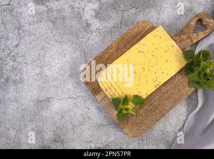 Fromage hollandais avec orties sur une planche en bois Banque D'Images