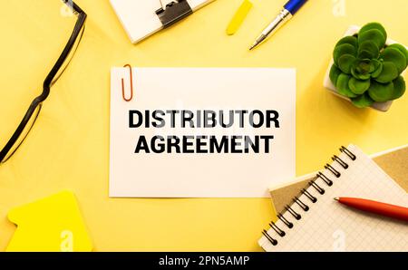 Sur une feuille de l'ACCORD DE DISTRIBUTEUR d'inscription de journal, à côté de lui est un crayon, des lunettes Banque D'Images