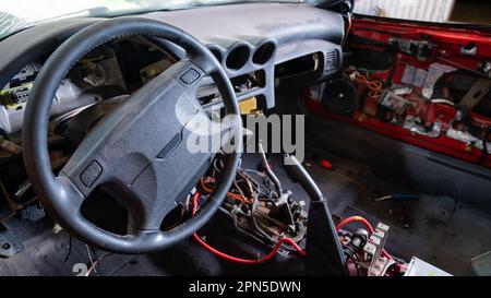 Intérieur de la voiture avec composants électriques démontés dans le garage. Banque D'Images