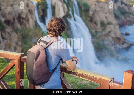 Homme touristique sur le fond de la cascade de Duden à Antalya. Lieux célèbres de la Turquie. Les chutes de Duden inférieures tombent d'une falaise rocheuse tombant d'environ 40 M. Banque D'Images
