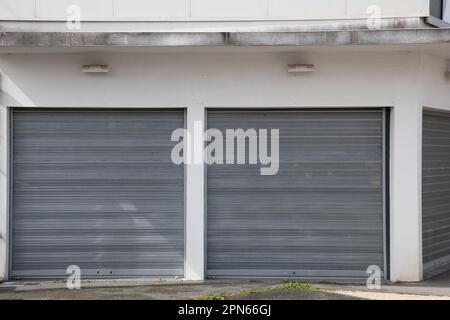 Volets roulants fermés sur la façade d'un magasin en faillite, double entrée de la boutique de fenêtres Banque D'Images