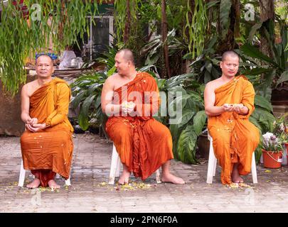 Ban Chang, Thaïlande - 16 avril 2023: 3 moines mouillés d'avoir de l'eau avec des pétales de fleur sur eux-mêmes pendant la célébration de Songkran, nouvel Ye bouddhiste Banque D'Images