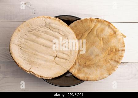 Deux pita cuites au four, en gros plan, sur une table en bois, vue de dessus. Banque D'Images