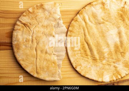 Deux pita cuites au four, en gros plan, sur une table en bois, vue de dessus. Banque D'Images