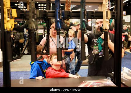 Indianapolis, États-Unis. 16th avril 2023. Une famille regarde les fusils lors des réunions et expositions annuelles de la National Rifle Association au centre de congrès de l'Indiana à Indianapolis. La convention, qui devrait attirer environ 70 000 invités a ouvert vendredi. Crédit : SOPA Images Limited/Alamy Live News Banque D'Images