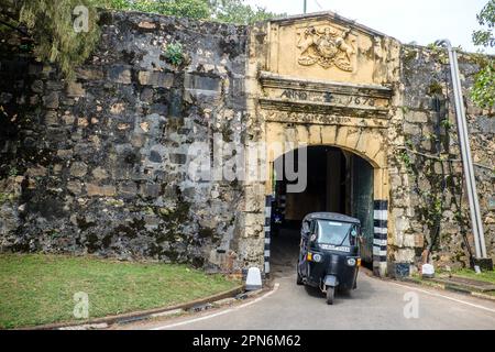 Tuk tuk émergent par la porte principale du fort Frederick à Trincomalee, Sri Lanka Banque D'Images