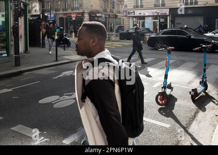 Les gens marchent par Location de trottinettes garées sur la route dans un parking désigné peint sur le sol, à Paris, France. Banque D'Images