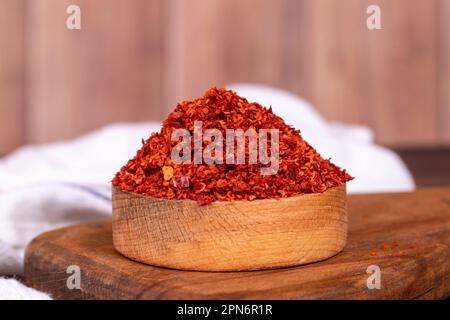 Flocons de piment sans pépins dans un bol en bois. Épices et ingrédients alimentaires. Gros plan Banque D'Images