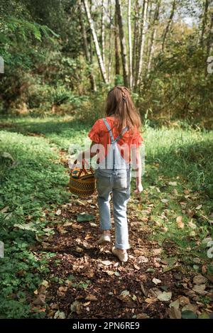 Fille marchant dans les bois avec panier Banque D'Images