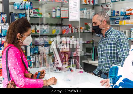 femme achetant dans une pharmacie, homme vendant les produits Banque D'Images