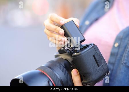 Gros plan portrait d'un photographe qui change la batterie de l'appareil photo Banque D'Images