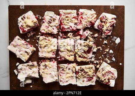 Barres de yaourt grec surgelé et sain avec fraise, zeste de lime, noix et chocolat blanc. Dessert sucré maison Banque D'Images