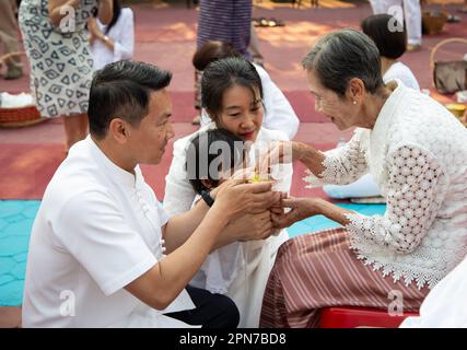 Lamphun, Thaïlande - 21 avril 2019: Festival traditionnel de Songkran. Les gens paient le respect et versent de l'eau sur la main des aînés à la Fête de Songkran. Banque D'Images