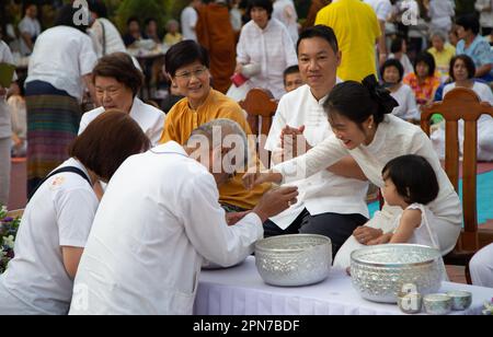 Lamphun, Thaïlande - 21 avril 2019: Festival traditionnel de Songkran. Les gens paient le respect et versent de l'eau sur la main des aînés à la Fête de Songkran. Banque D'Images