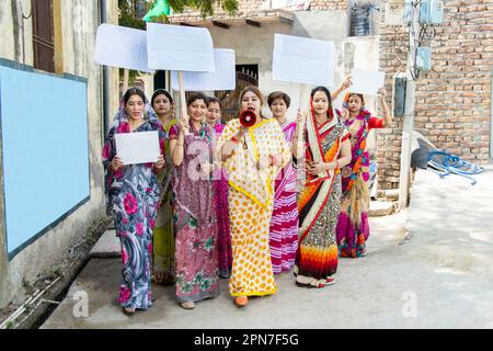 Groupe de femmes indiennes traditionnelles portant une étiquette en carton vierge pour protester contre la chute du mégaphone. Militante protestant avec le mégaphone pendant un Banque D'Images