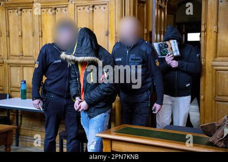 Brême, Allemagne. 17th avril 2023. Les accusés sont conduits dans la salle d'audience. Les hommes, âgés de 26 et 41 ans, auraient attaqué brusquement un autre homme, avec sa petite amie qu'ils avaient précédemment assise, en octobre 2022. Ils auraient frappé et poignardé à plusieurs reprises l'homme qui ne se doutait pas. Quand l'homme était sur le sol, ils lui auraient donné des coups de pied jusqu'à ce que la petite amie ait accepté d'aller avec les attaquants. L'homme a saigné à mort et est mort sur la scène. Credit: Sina Schuldt/dpa - ATTENTION: Personne(s) ont été pixelated pour des raisons juridiques/dpa/Alay Live News Banque D'Images