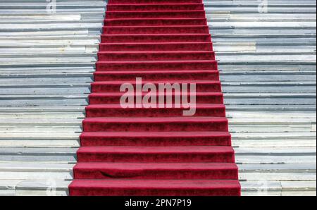 Tapis rouge sur les escaliers en marbre, Panagia de l'île de Tinos, Cyclades, Grèce. Entrée de fête en velours vide Banque D'Images