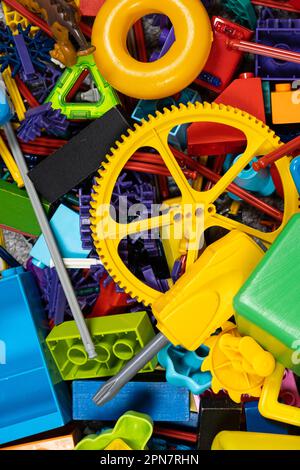 Une abondance de jouets dans la chambre des enfants, beaucoup de pièces en plastique multicolores de designers, pièces de rechange pour jouets, figurines et cubes. Banque D'Images