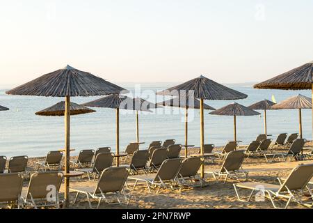 Vue sur les parasols en bois et les chaises longues sur une plage méditerranéenne Banque D'Images