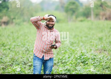 Joyeux agriculteur indien, jeune fermier souriant dans la ferme Banque D'Images