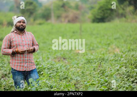 Joyeux agriculteur indien, jeune fermier souriant dans la ferme Banque D'Images