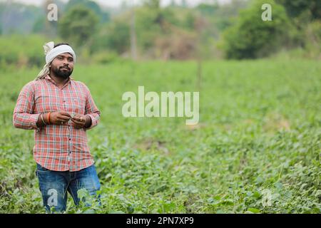 Joyeux agriculteur indien, jeune fermier souriant dans la ferme Banque D'Images