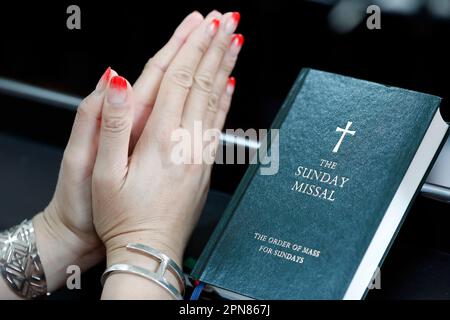 Église Saint-Joseph. Femme priant seule dans une église. Dimanche Missal. Singapour. Banque D'Images