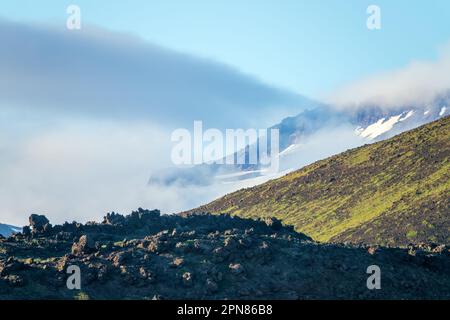 Les nuages roulent dans la vallée. Panorama des montagnes volcanogènes. Lave et pyroclaste au premier plan Banque D'Images