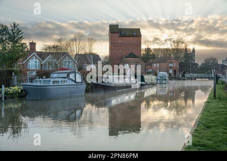 Vue sur le canal Kennet et Avon avec le pont tournant de West Mills et l'église St Nicolas à distance au lever du soleil, Newbury, Berkshire, Angleterre, Royaume-Uni Banque D'Images